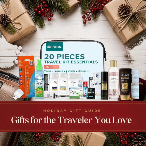 3ozs holiday gift guide: TrekTote travel hygiene kit with travel-size hair care, Tide To Go pen and Febreze Fabric To Go on a festive table with kraft-wrapped gifts, pine and red berries. Gifts for the Traveler You Love.