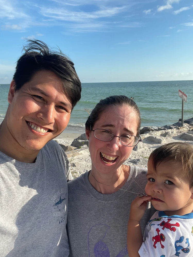 Family enjoying a beach day with a child overlooking the ocean