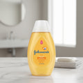 A 100ml, 3.4 oz container Johnson's baby shampoo bottle on a bathroom counter