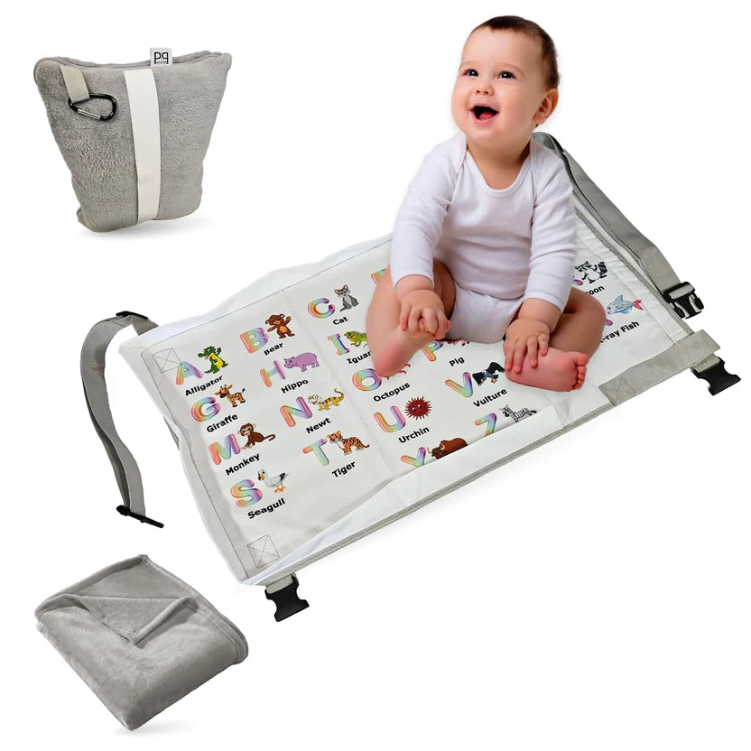 Baby sitting on a portable play mat with educational designs. The play mat folds up into a carry-on bag.