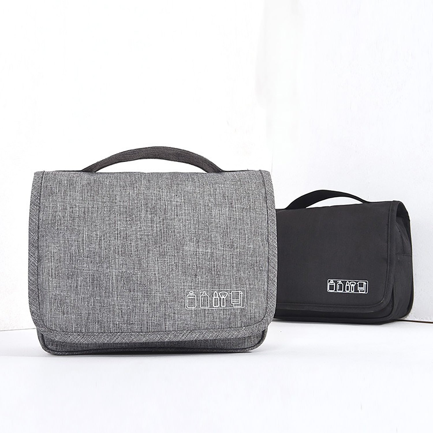 Gray and black toiletry bags with handles on a white background