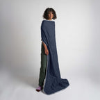 Person wearing a long navy-blue blanket on a white background