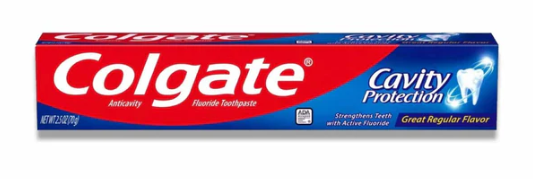 A travel-sized Colgate cavity protection toothpaste tube on a white background