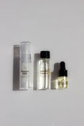 Set of skincare products including a spray, bottle, and dropper on a light gray background