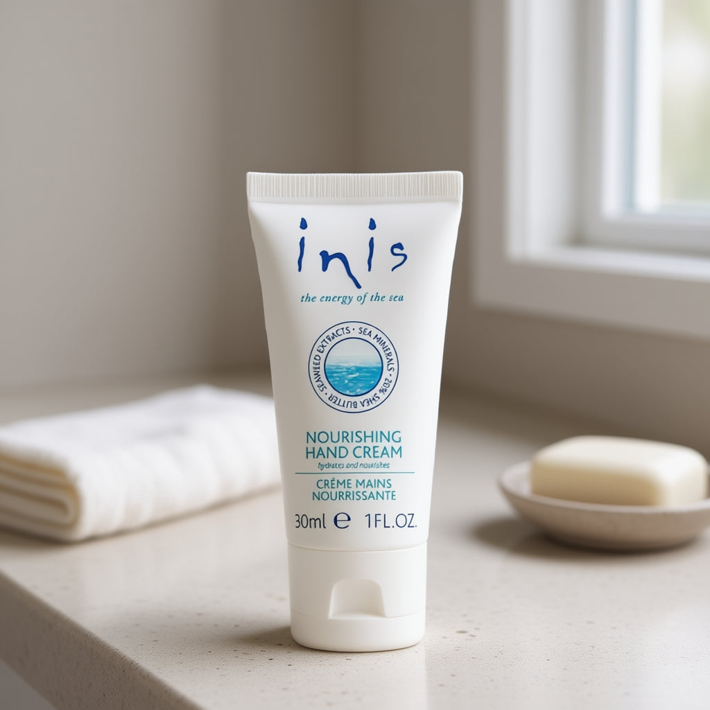 Tube of inis nourishing hand cream on a bathroom counter with a towel and soap dish in the background.