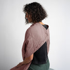 Person wearing a two-tone jacket with a plain background