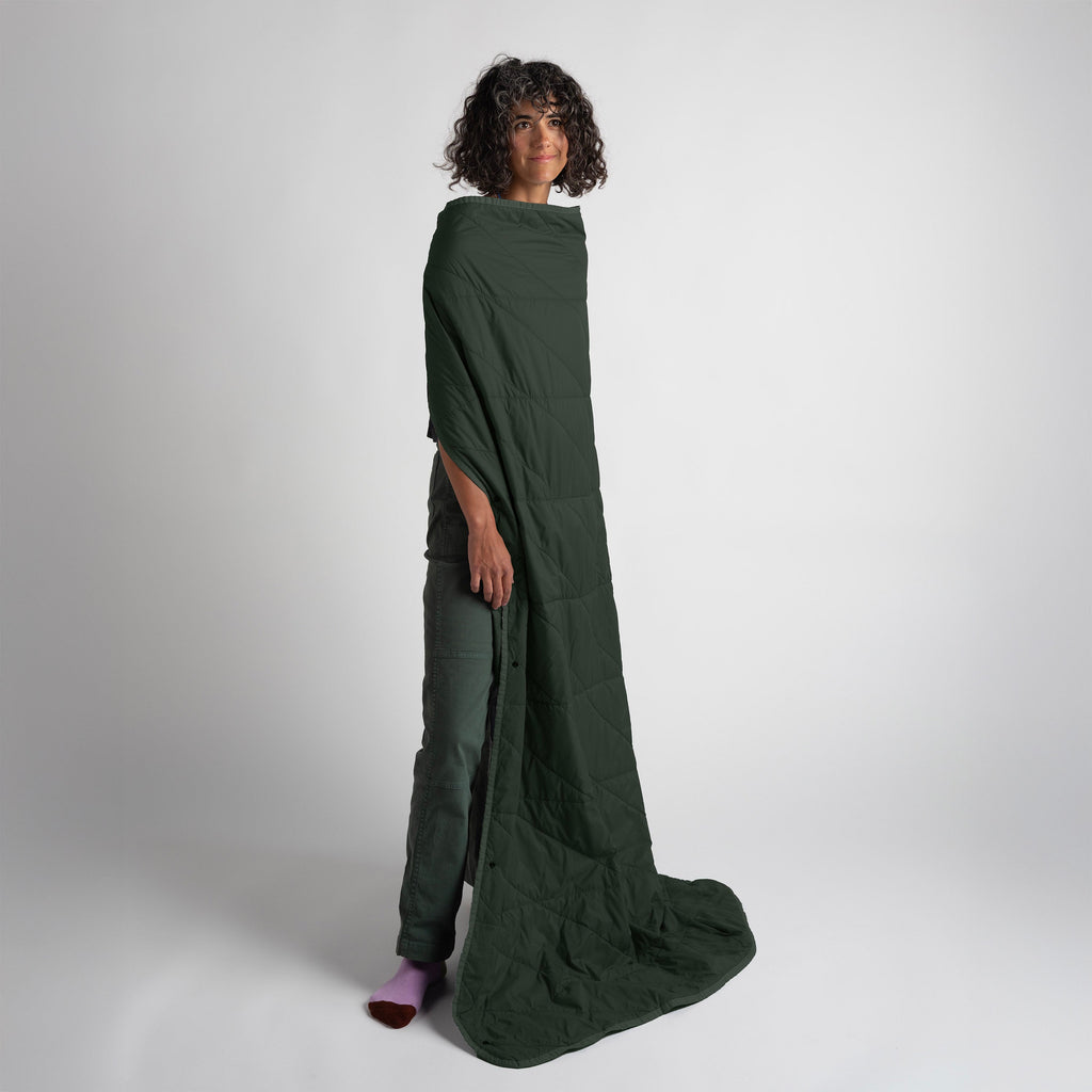 Person wearing a long green dress against a white background