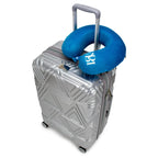 Silver suitcase with a blue neck pillow on a white background