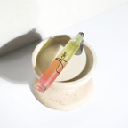 Lip gloss with a gradient color on a white surface