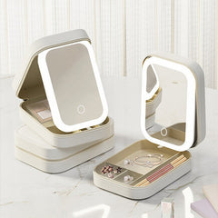 Two warm white compact mirrors with LED lights on a white surface.