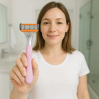 Woman holding a pink and orange razor in a bathroom setting
