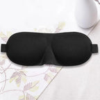Black sleep mask on a light-colored fabric background