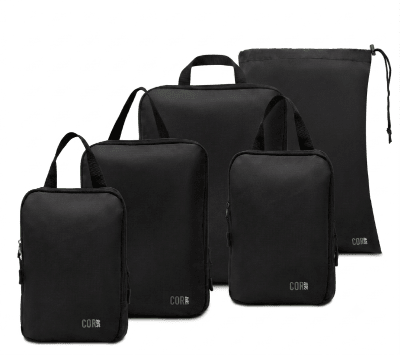 Four black travel packing cubes of different sizes with matching black drawstring storage pouches, arranged on a clean white background. Each bag features a small green 'CORN' logo near the bottom.