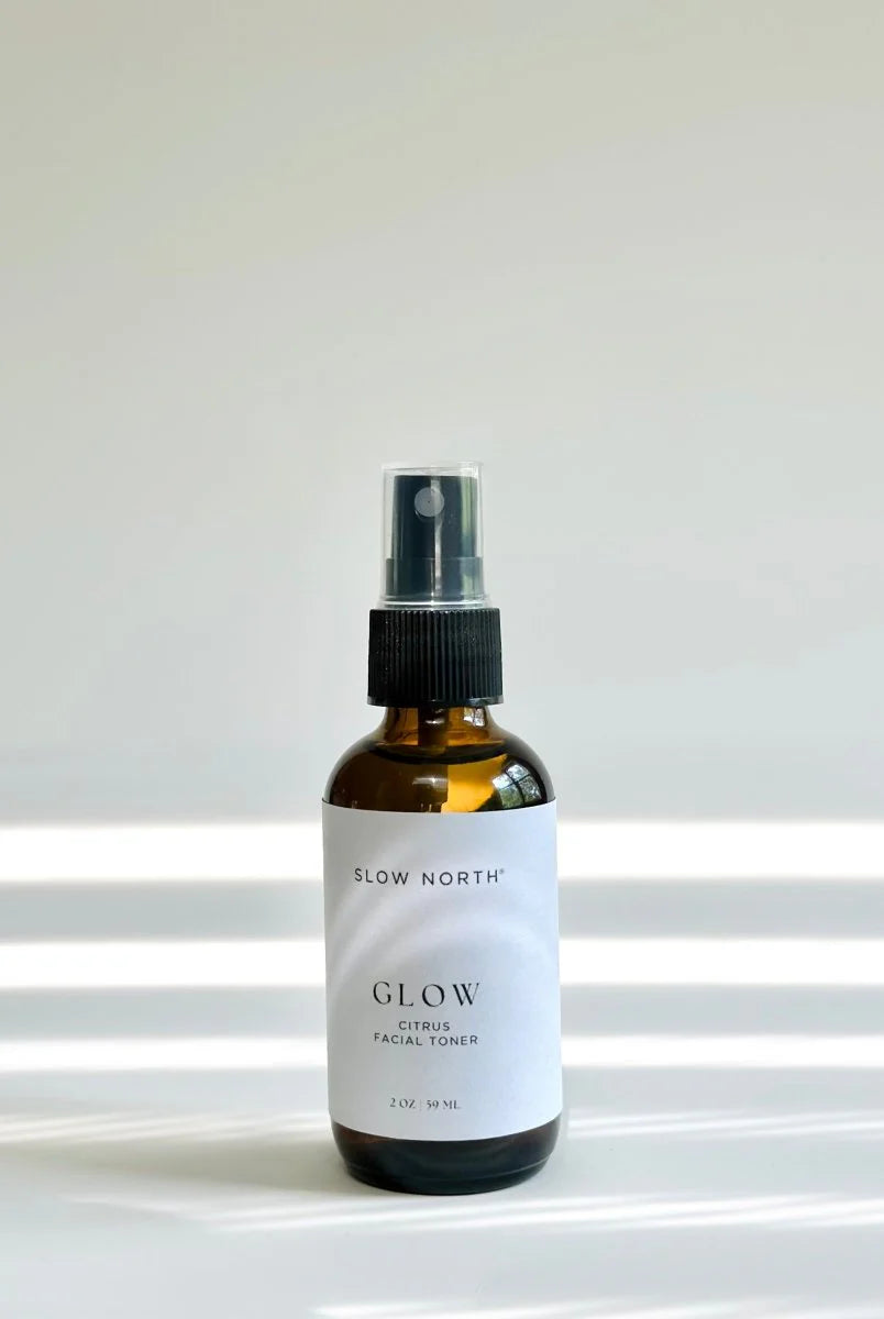 Bottle of Slow North Glow facial toner on a white surface with a light gray background