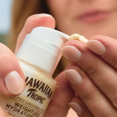 Hawaiian Tropic Silk Hydration Weightless Face Sunscreen SPF 30 in hand, perfect for travel size essentials.