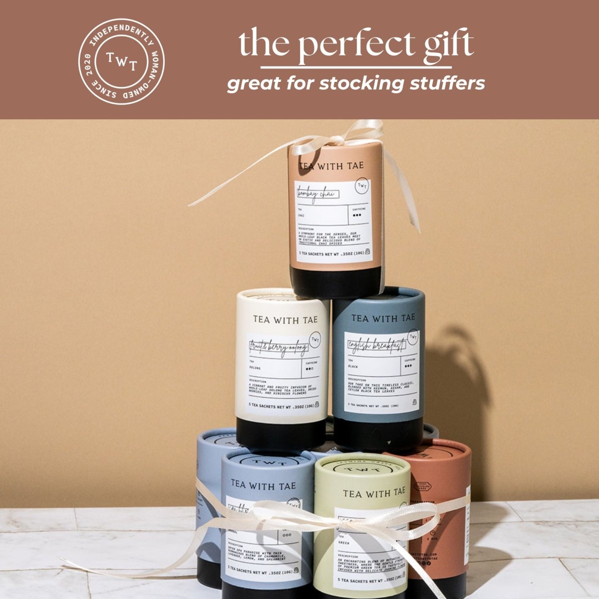 Stack of 'Tea with Tae' tea canisters on a beige background with text about it being a perfect gift.