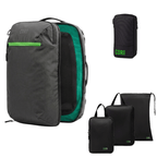 A dark gray and green Corepack backpack shown open, alongside three black compression sleeves of different sizes and a small black pouch with a green Corepack logo, all on a white background.