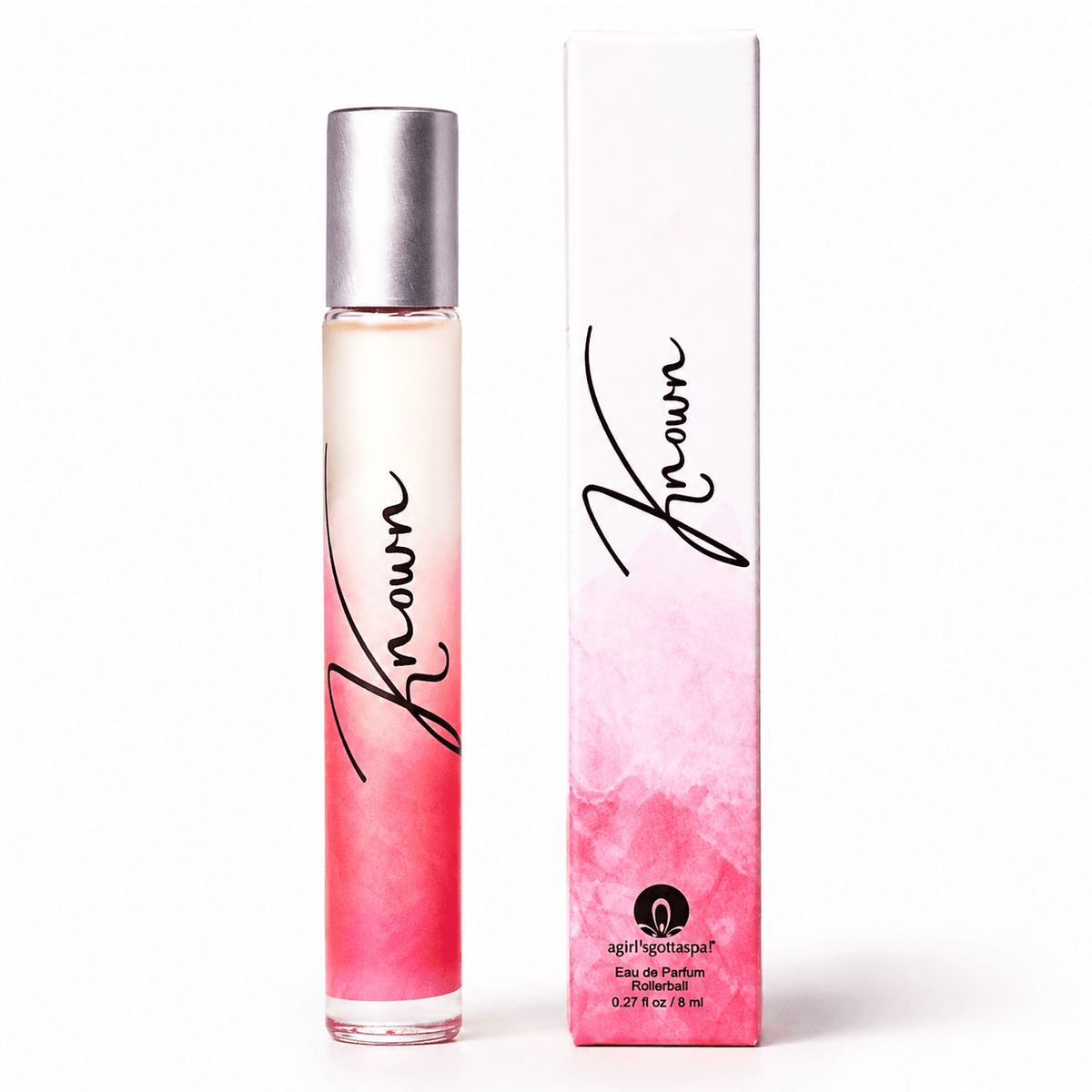 A 10 ml rollerball perfume bottle with a silver cap next to its white and pink packaging box. The bottle features a pink ombre watercolor design, and both items display the brand name 'Known' in black script.