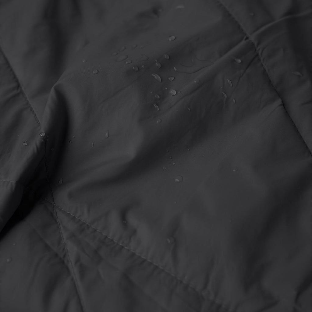 Close-up texture of Layover™ XL Travel Blanket | Black with water droplets.