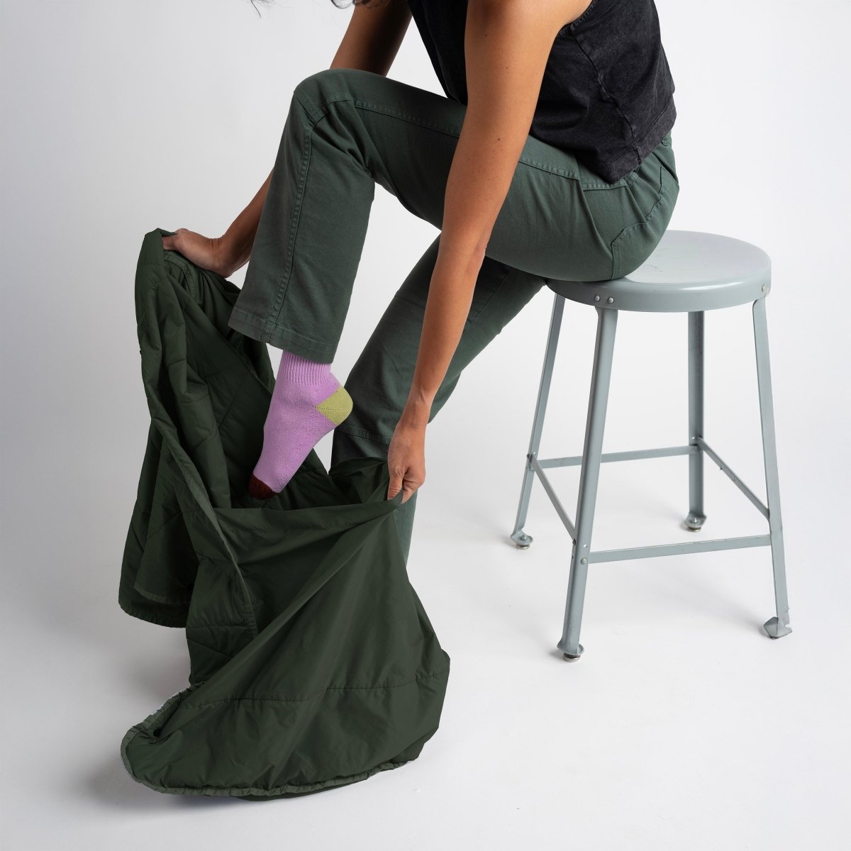 Layover™ XL Travel Blanket | Spruce being worn for comfort