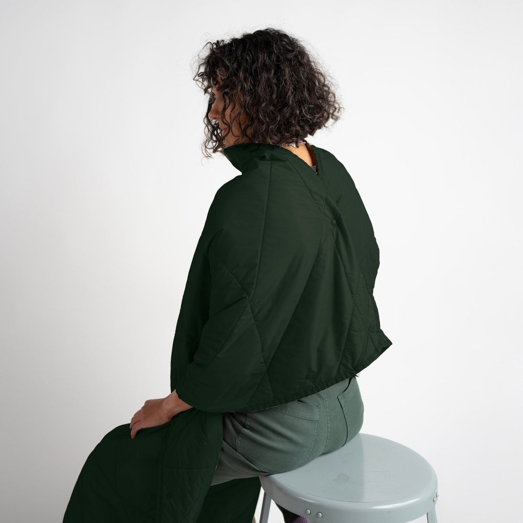 Layover™ XL Travel Blanket | Spruce on a seated model