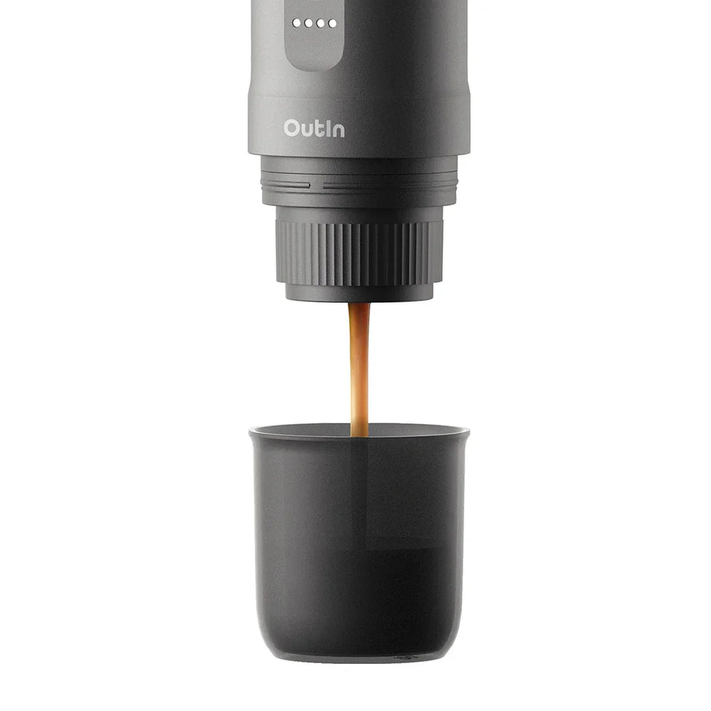 Portable coffee maker dispensing coffee into a black cup on a white background