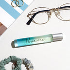 Roll-on bottle with 'Persevere' text, glasses, and scrunchies on a textured surface