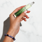 Hand holding a green rollerball labeled 'Resilient' against a white background