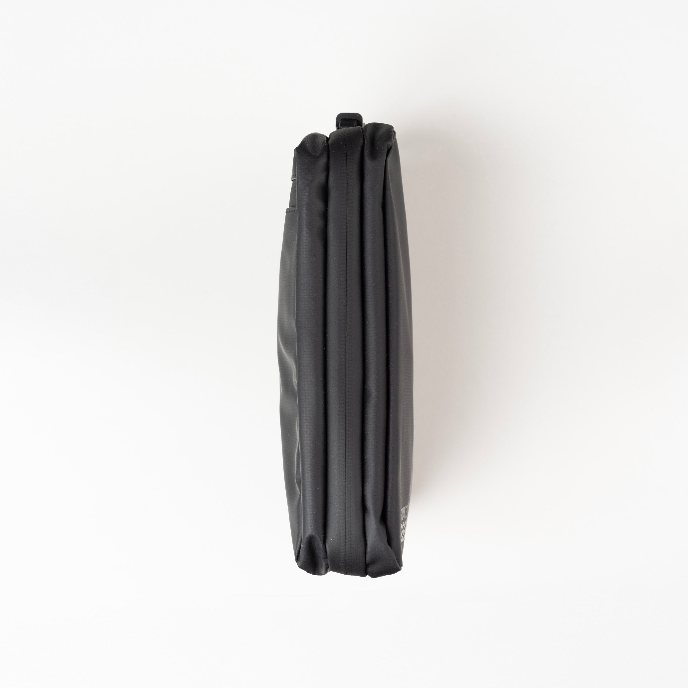 Black umbrella folded and placed on a white background