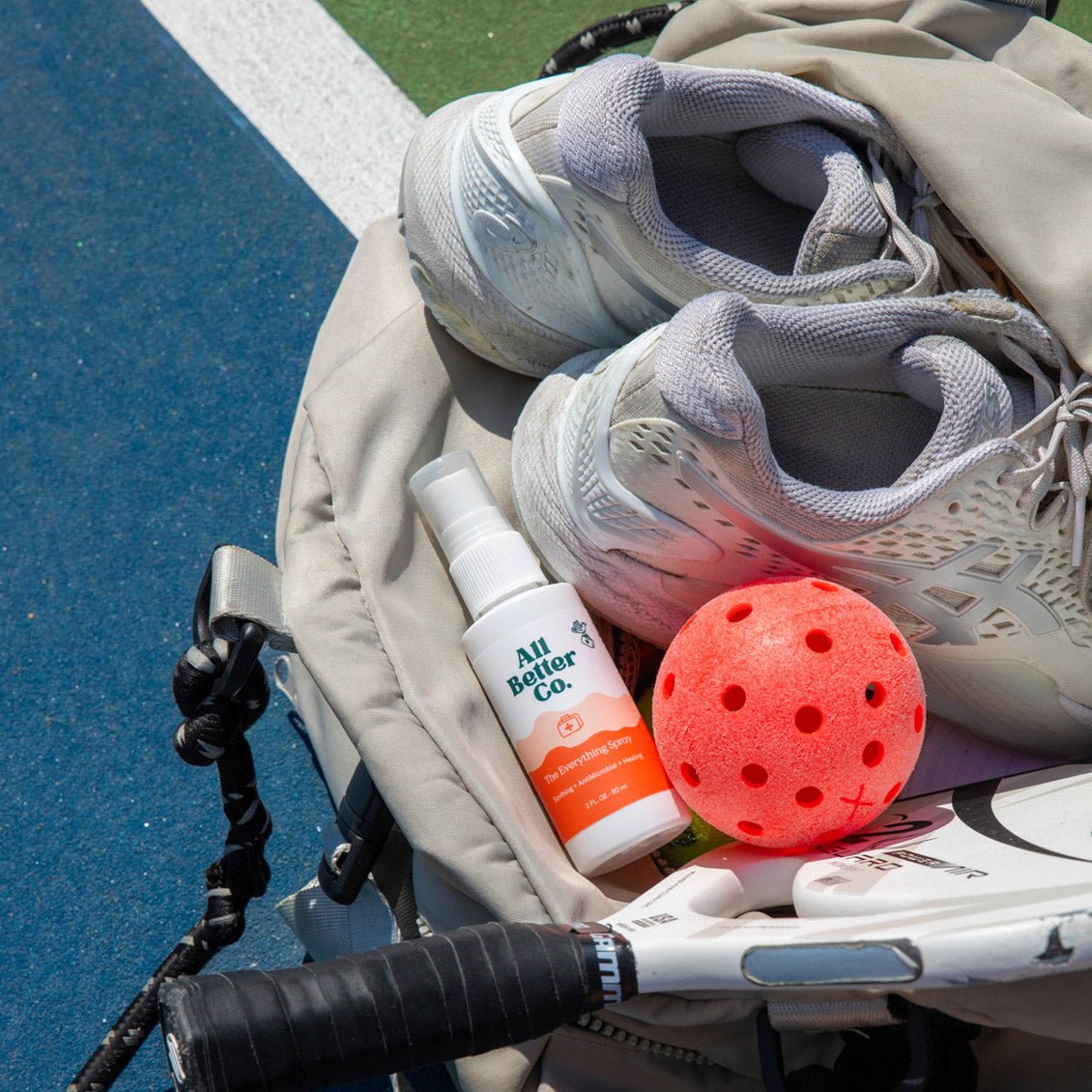 The Everything Spray in a sports bag with sneakers.