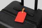 The Luggage Tag on a sleek black suitcase for easy identification.