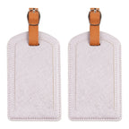 The Luggage Tag in light color with brown strap.