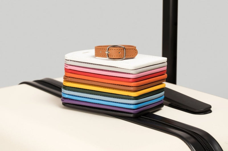 The Luggage Tag in vibrant colors on a suitcase.