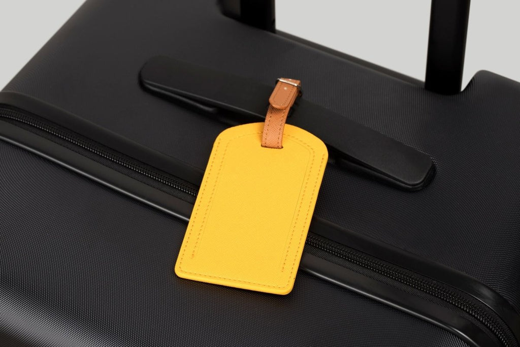 The Luggage Tag on a black suitcase, perfect for travel essentials.