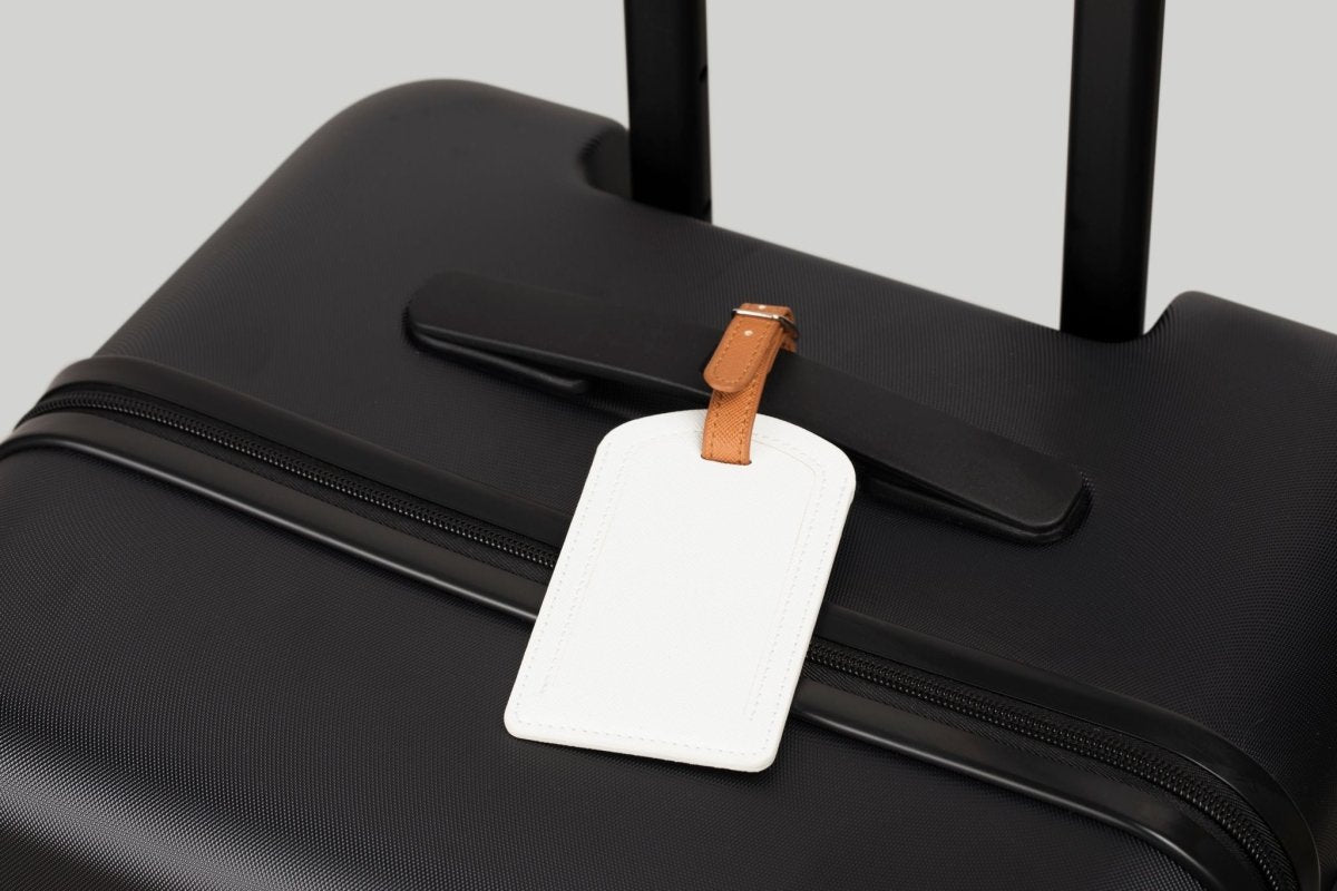 The Luggage Tag on a black suitcase for easy travel identification.