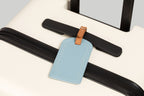 The Luggage Tag in blue on a suitcase for travel.