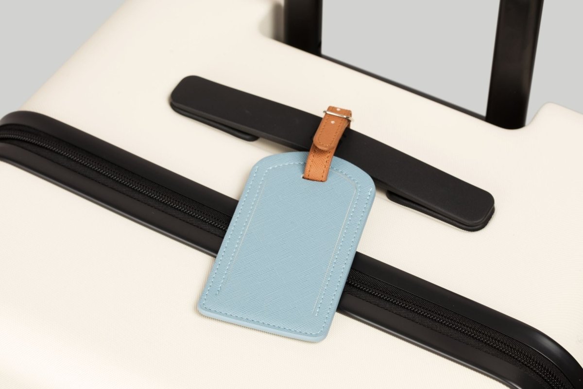 The Luggage Tag in blue on a suitcase for travel.