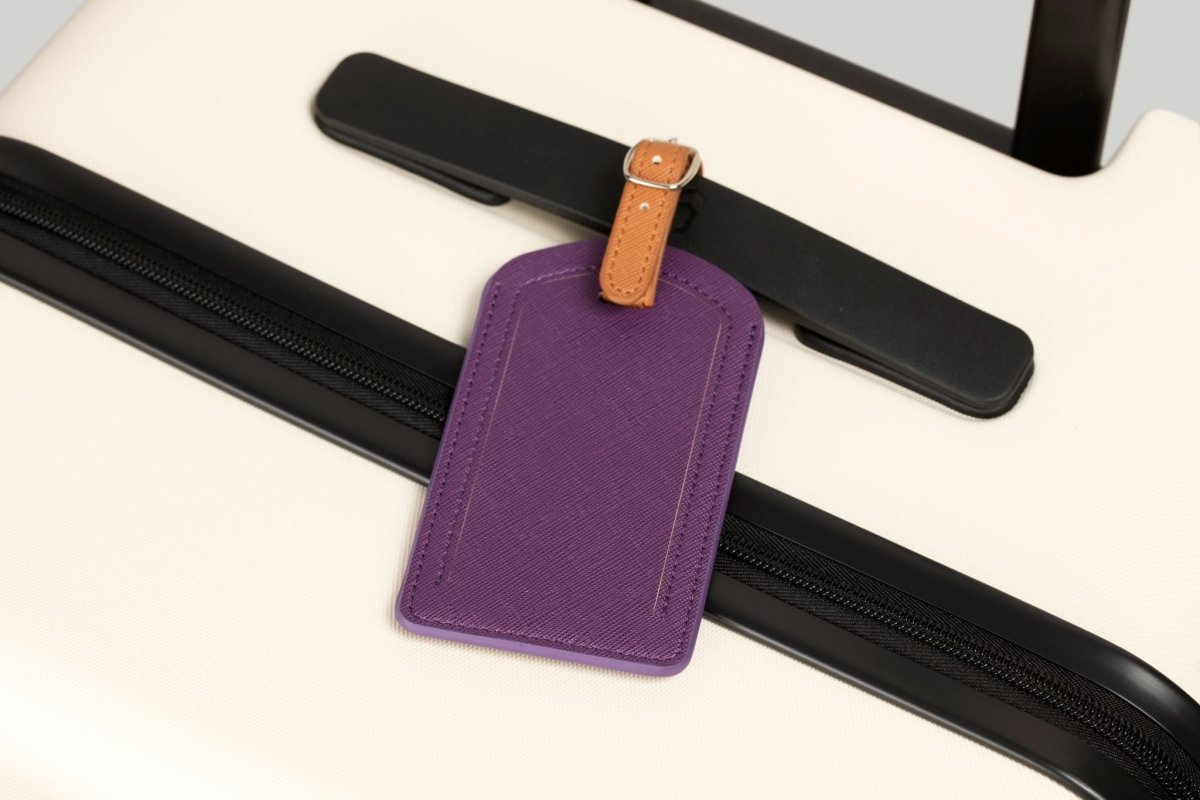 The Luggage Tag in purple on a suitcase for easy travel.