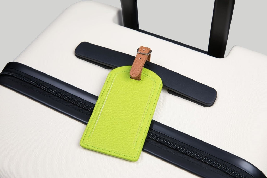 The Luggage Tag in vibrant green on a suitcase.