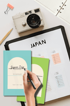 Hand writing in blue and green Everywhere travel planners beside a camera and a Japan guide