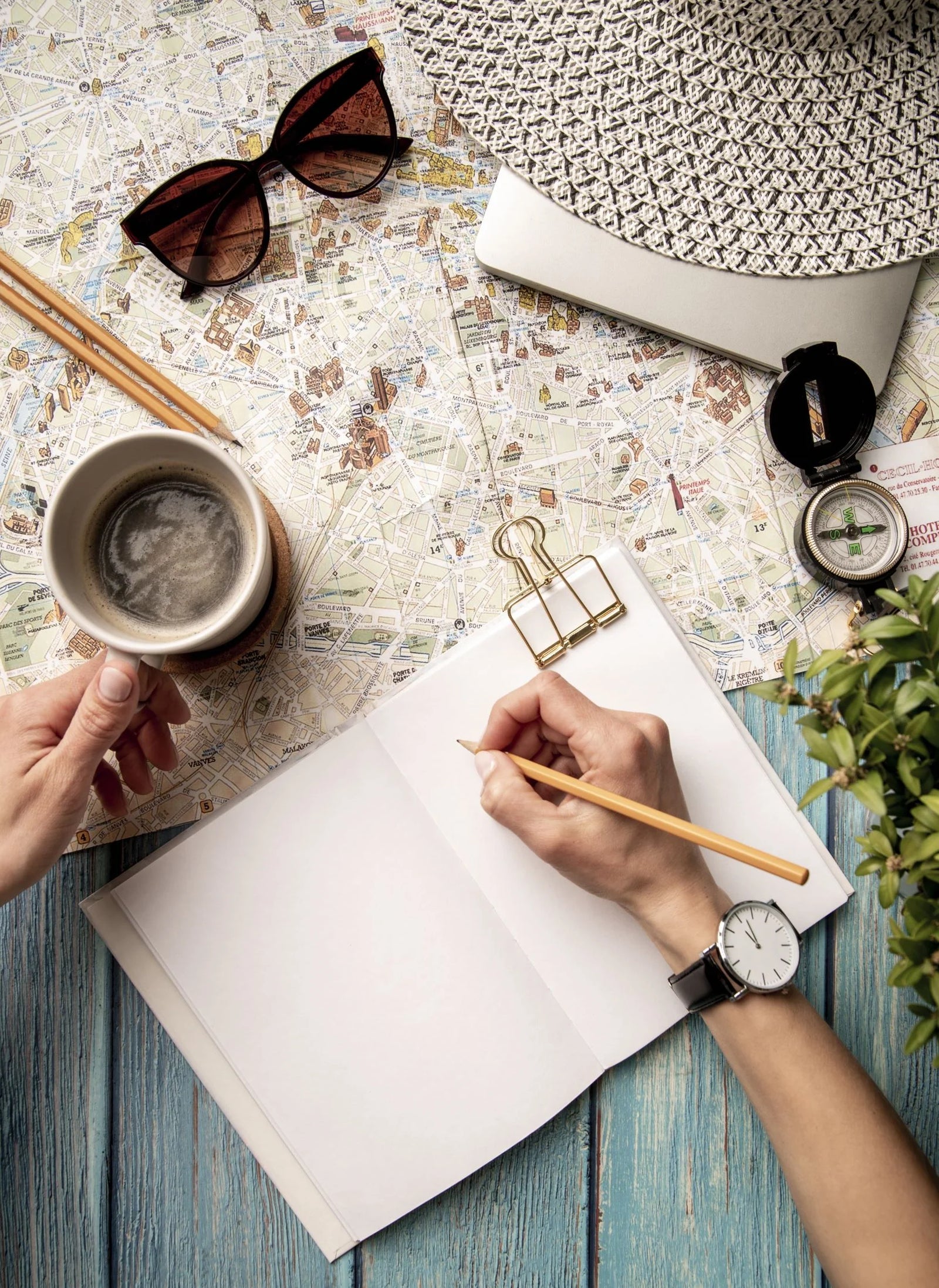 Traveler planning a trip with map, notebook, and coffee.